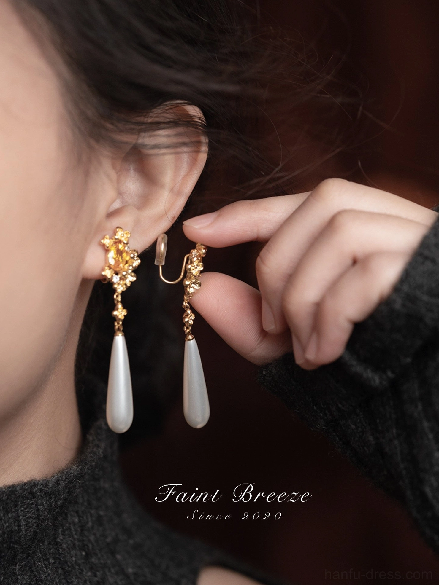 Close side view of woman adjusting convertible osmanthus pearl drop Chinese earrings with elegant floral and pearl details