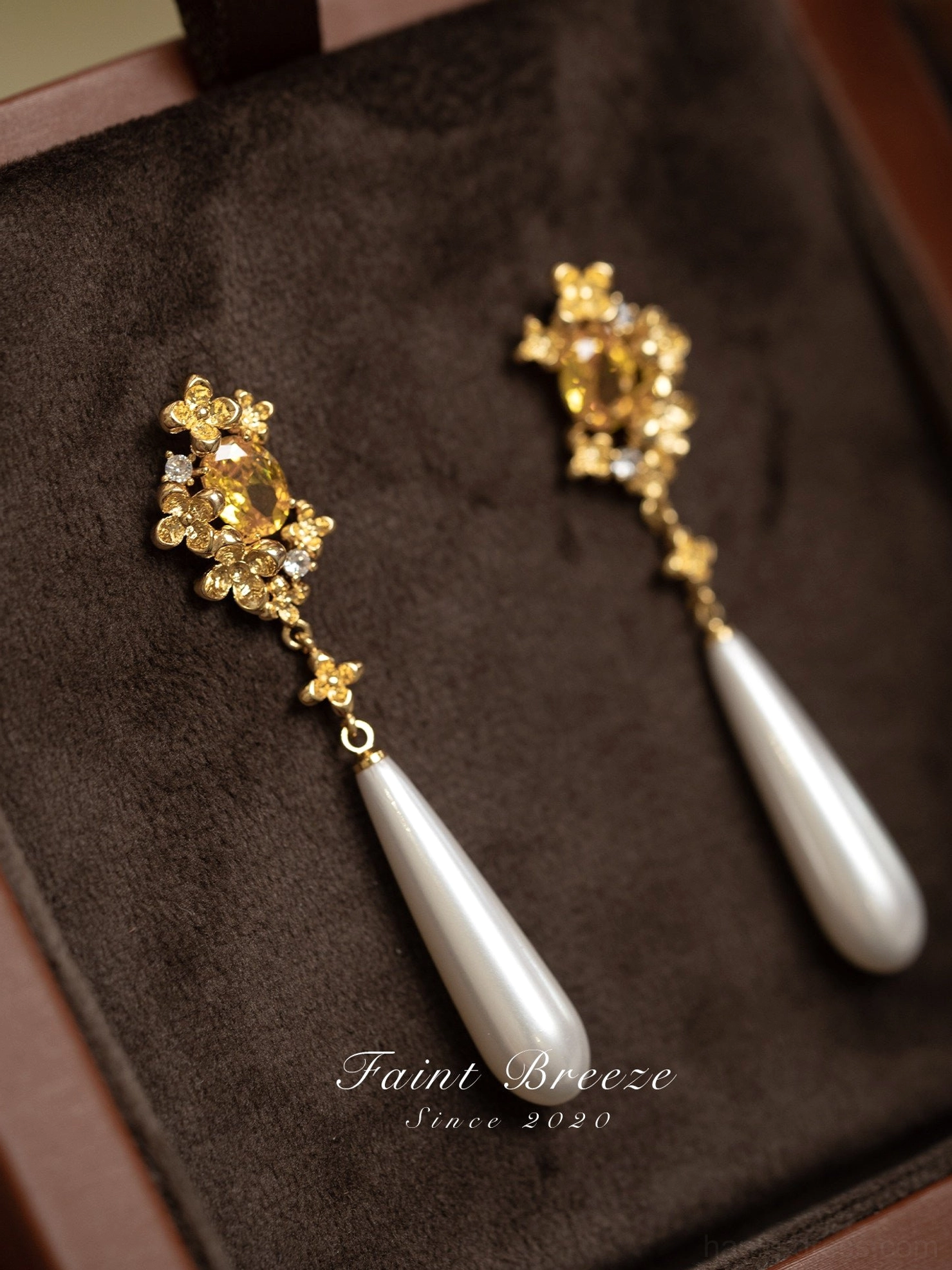 Detailed close-up of gold osmanthus flower Chinese earrings with yellow center gems, tiny accent stones, and white pearl drops