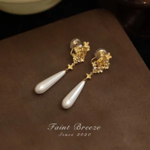 Osmanthus pearl drop Chinese earrings with gold floral settings, yellow center stones, and white teardrop pearl pendants on brown velvet