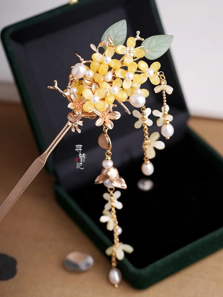 Osmanthus pearl tassel Chinese hairpin pair displayed on a dark green velvet jewelry box showing gold flowers green leaves and long dangling tassels