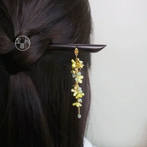 Osmanthus tassel Chinese hair stick worn in a half-up hairstyle, featuring yellow floral ornaments, pale green beads, gold-tone details, and a dark hairpin for Hanfu styling