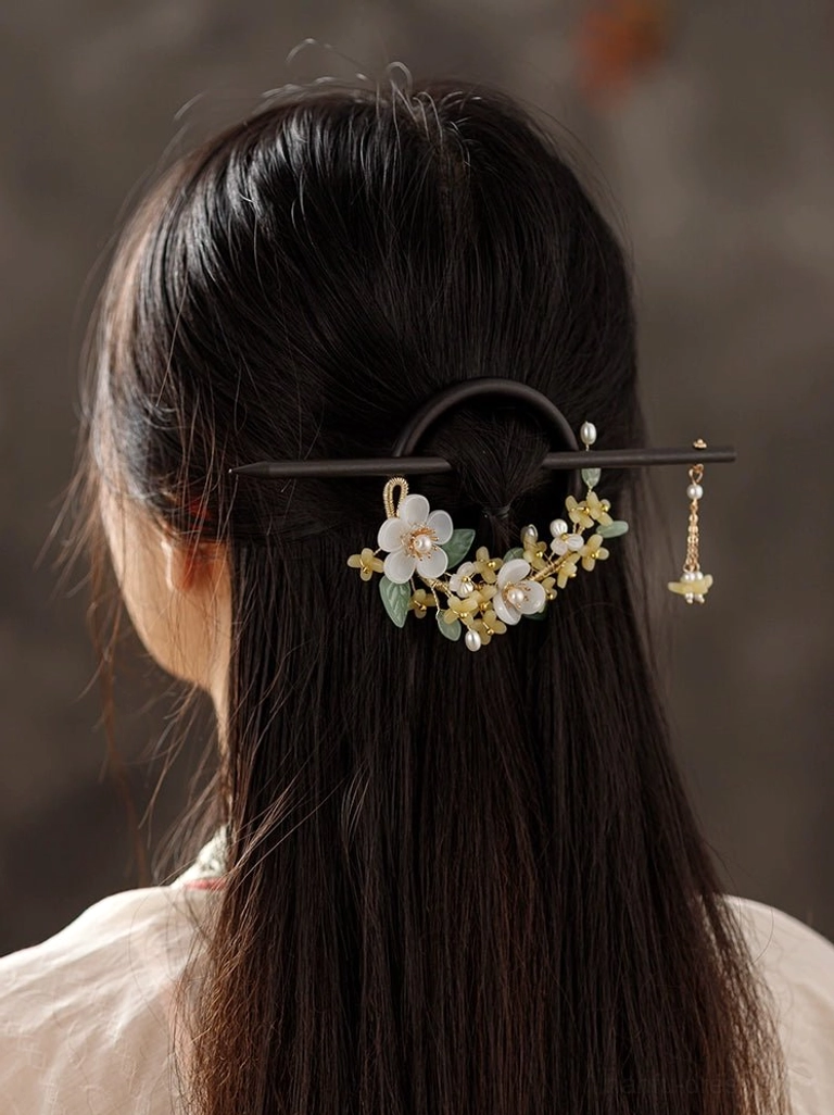 Back view of a woman wearing an elegant osmanthus floral wooden hair pin with pearl tassel and casual Hanfu clothing