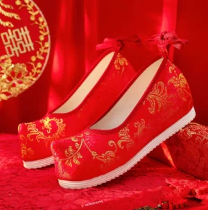 Pair of red Chinese wedding Hanfu shoes with golden vine embroidery, decorative heel bows, upturned toe caps, and hidden height-increasing soles