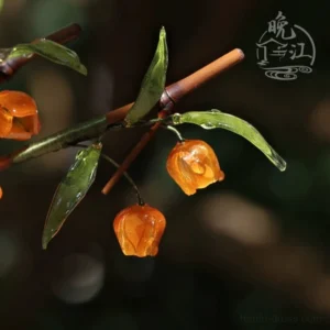 Palace lantern berry Chinese hair stick with orange resin berries, translucent green leaves, and brown bamboo style shaft in outdoor close-up
