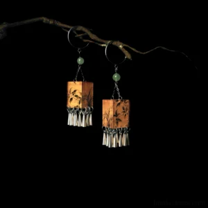 Palace lantern orchid tassel Chinese earrings hanging on a dry branch against a black background
