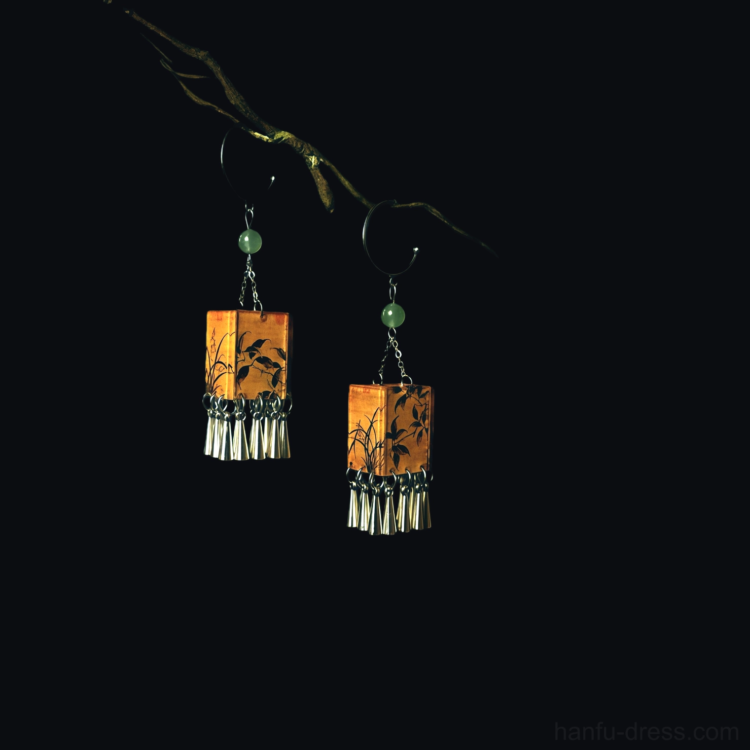 Pair of vintage palace lantern orchid tassel earrings displayed on dry branches against black background