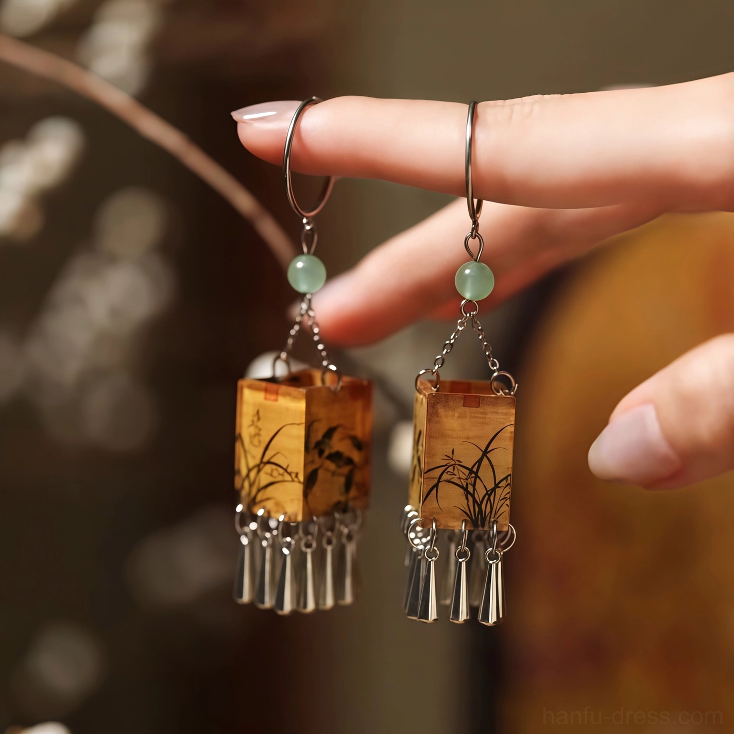 Close-up of yellow orchid print palace lantern tassel Chinese earrings held in hand