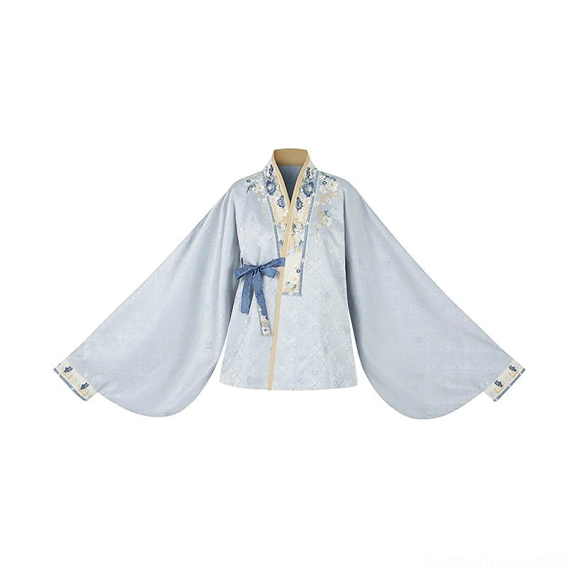 Flat lay of a pale blue Ming Dynasty Hanfu cross-collar top with wide lantern sleeves, embroidered neckline trim, and matching attached waist sash