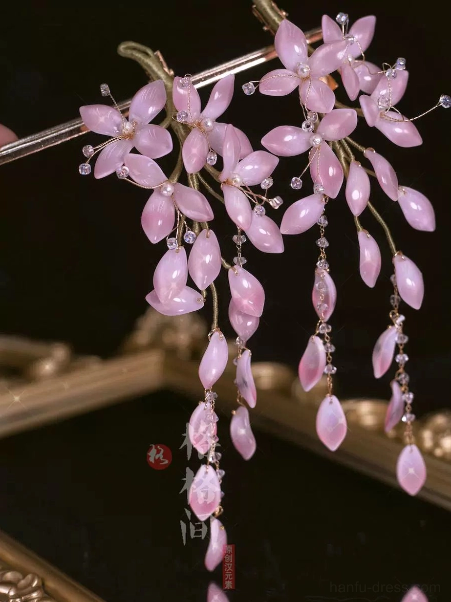 Pale pink wisteria glass hair pins with clustered flower petals dangling bead tassels and crystal accents on black velvet