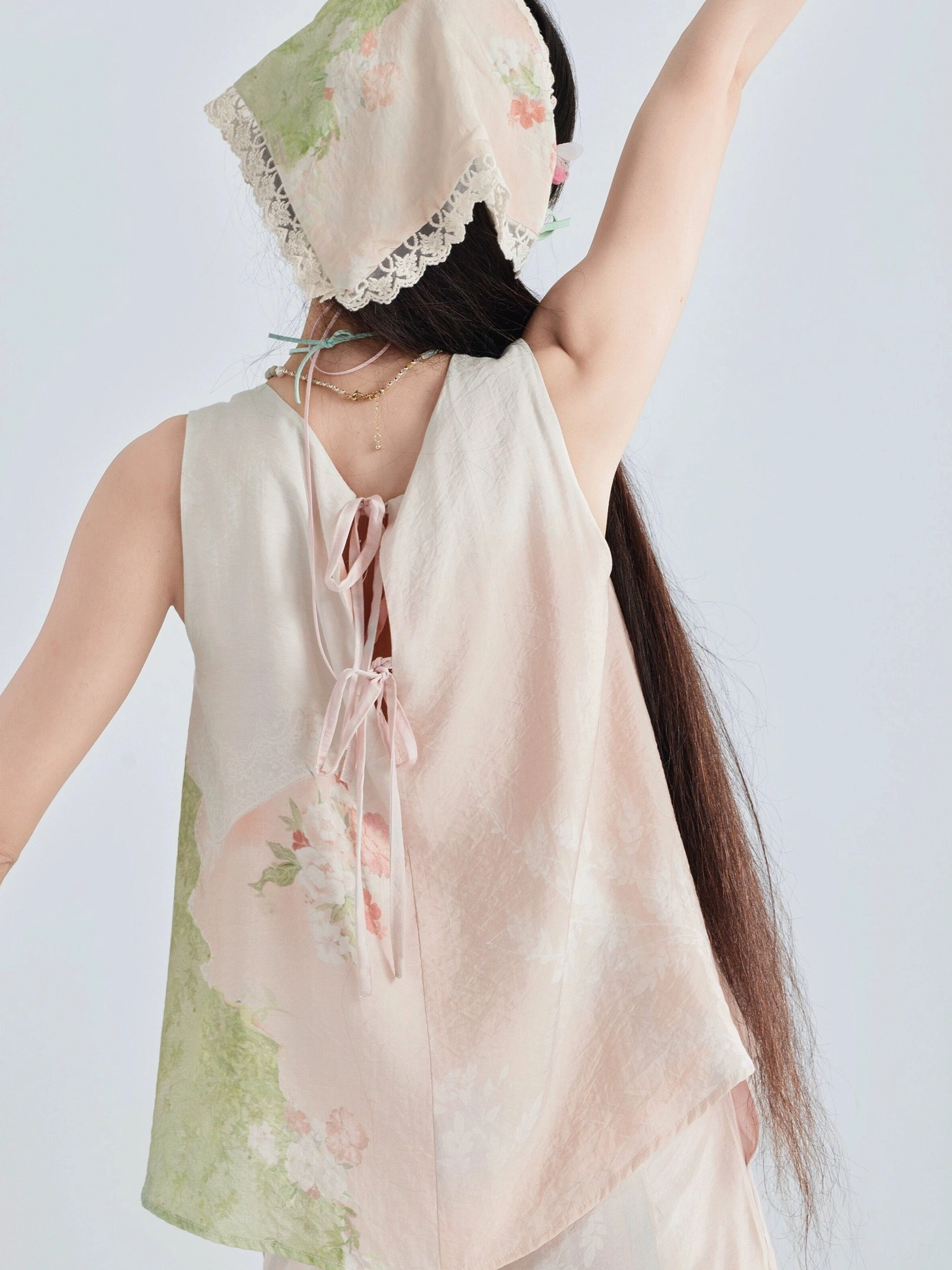 Back view of a pastel floral modern Hanfu camisole with tie-up back closure and lace-trimmed triangular headscarf