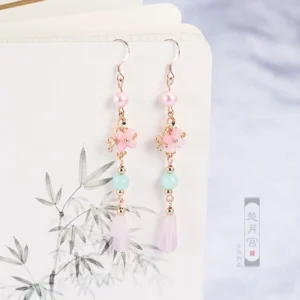 Pastel pink and mint floral Hanfu drop earrings with gold accents and teardrop pendants on a traditional painting notebook