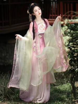 Peach Blossom God Tang Dynasty Hanfu dress in ombre pink with peach blossom embroidery and a flowing light green sheer shawl, modeled in a classical Chinese garden