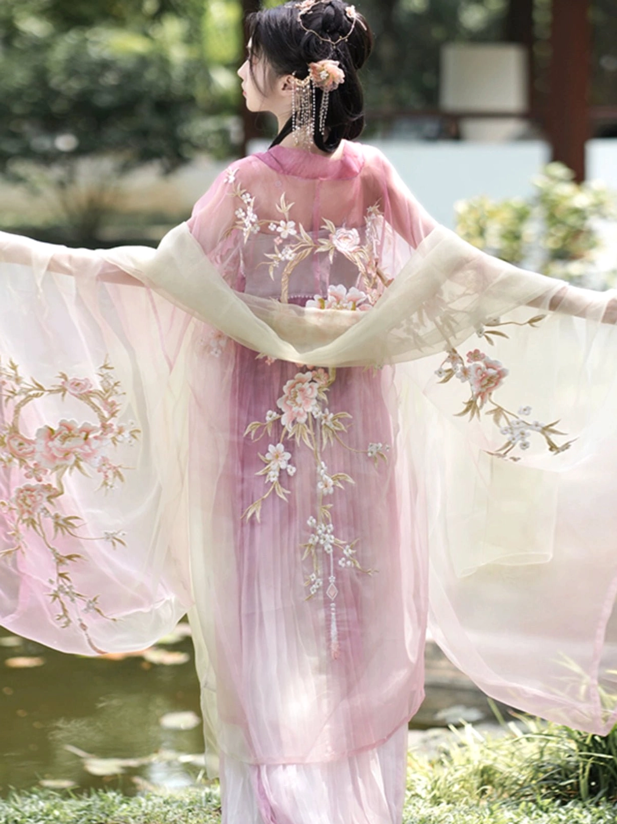 Back view of Peach Blossom God Tang Dynasty Hanfu showing peach blossom branch embroidery on the dress and sheer shawl with wide flowing sleeves