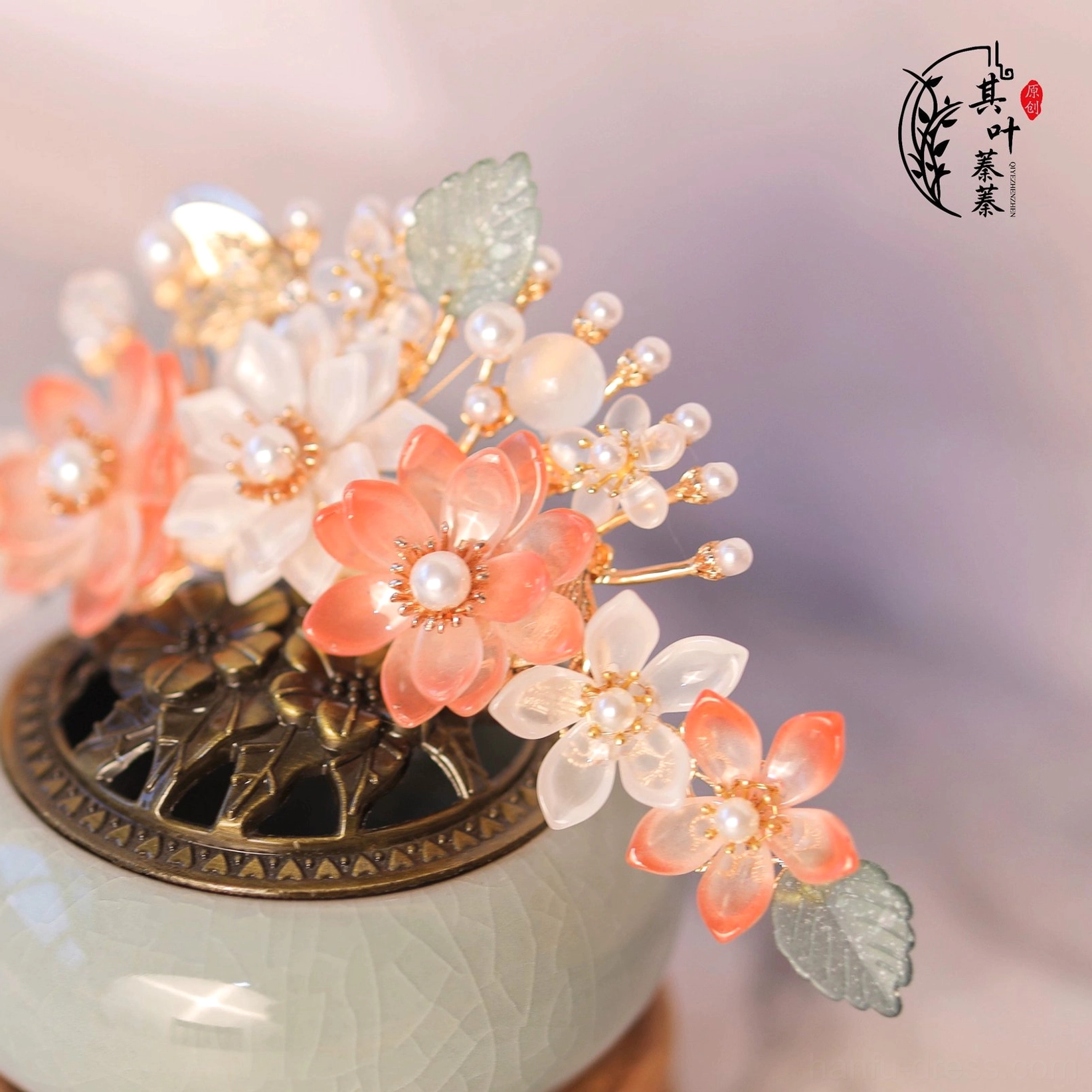 Close up of peach pink and milky white flower Hanfu hair ornament with pearls, green leaf accents and gold tone metal details