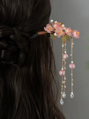 Peach blossom tassel Chinese hair stick worn in a dark braided updo with pink flowers faux pearls and crystal drop chains