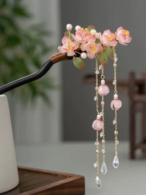 Pink peach blossom Chinese hair stick flat lay with dark pin green leaves faux pearls and gold tone crystal tassels