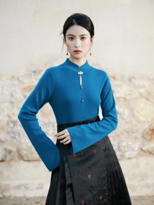 Modern Hanfu peacock blue cashmere blend knitted sweater styled with a black embroidered mamian skirt in a three-quarter front view