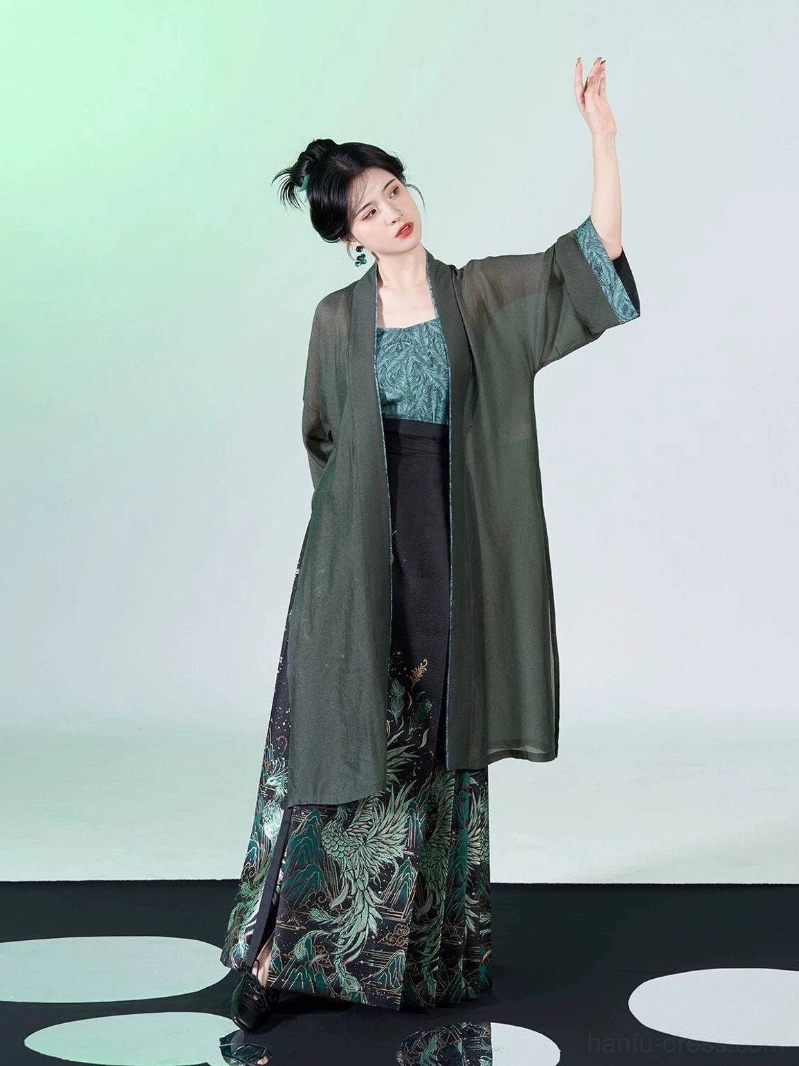 Dynamic front view of peacock feather Hanfu outfit with flowing green overcoat and black Ming Dynasty inspired mamian skirt