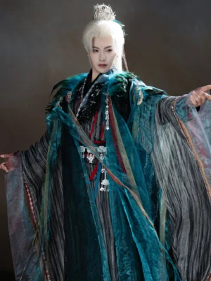 Close-up front view of unisex Peacock King Hanfu costume featuring layered black inner top, peacock-blue outer robe, wide sleeves, silver hanging waist ornaments, contrasting trims, and fantasy-inspired details