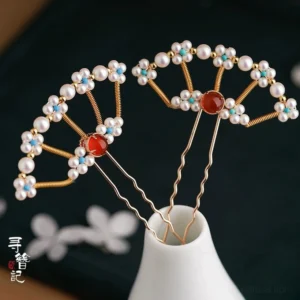 Chinese-style pearl fan-shaped U-shaped hairpin with gold-tone metal frame, turquoise floral ornaments, and red agate centerpiece displayed against dark fabric