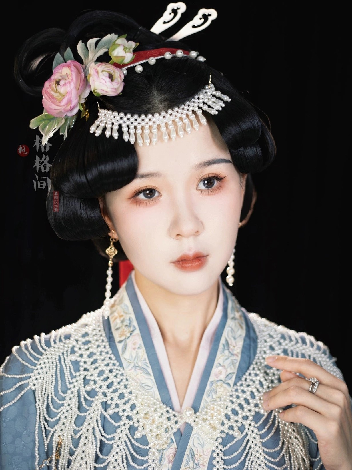 Front portrait of traditional Chinese hairstyle styled with pearl fringe Hanfu hair accessory, floral hairpins, and jade style hair sticks