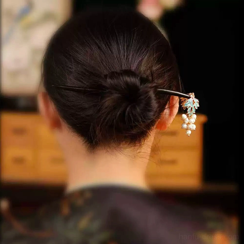Model wearing a pearl grape Chinese hair stick in a neat low bun with a vintage floral outfit and traditional styling