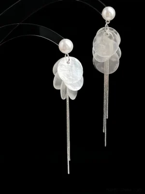 Front view of pearl shell tassel Chinese earrings with layered translucent shell pendants and long silver tassel strands on a black background