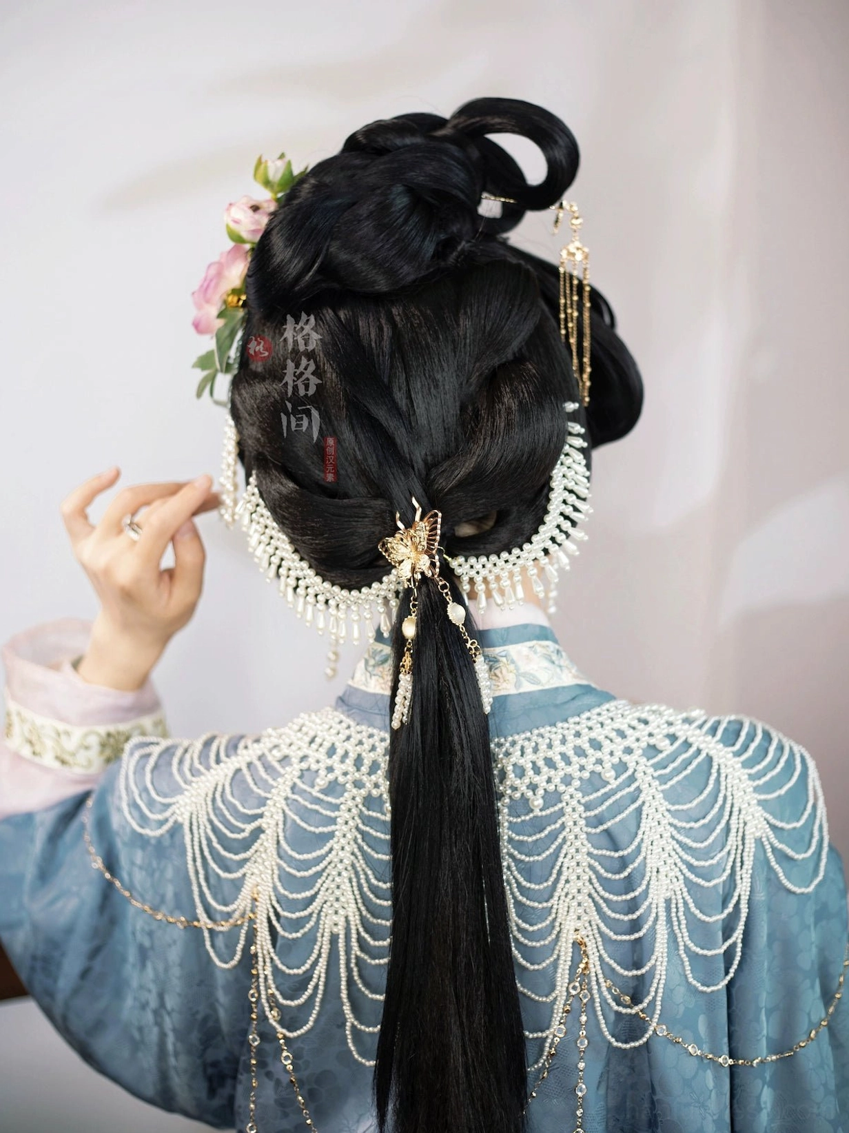 Back view of braided Hanfu hairstyle decorated with pearl tassel hair accessory, butterfly clasp, and gold chain details