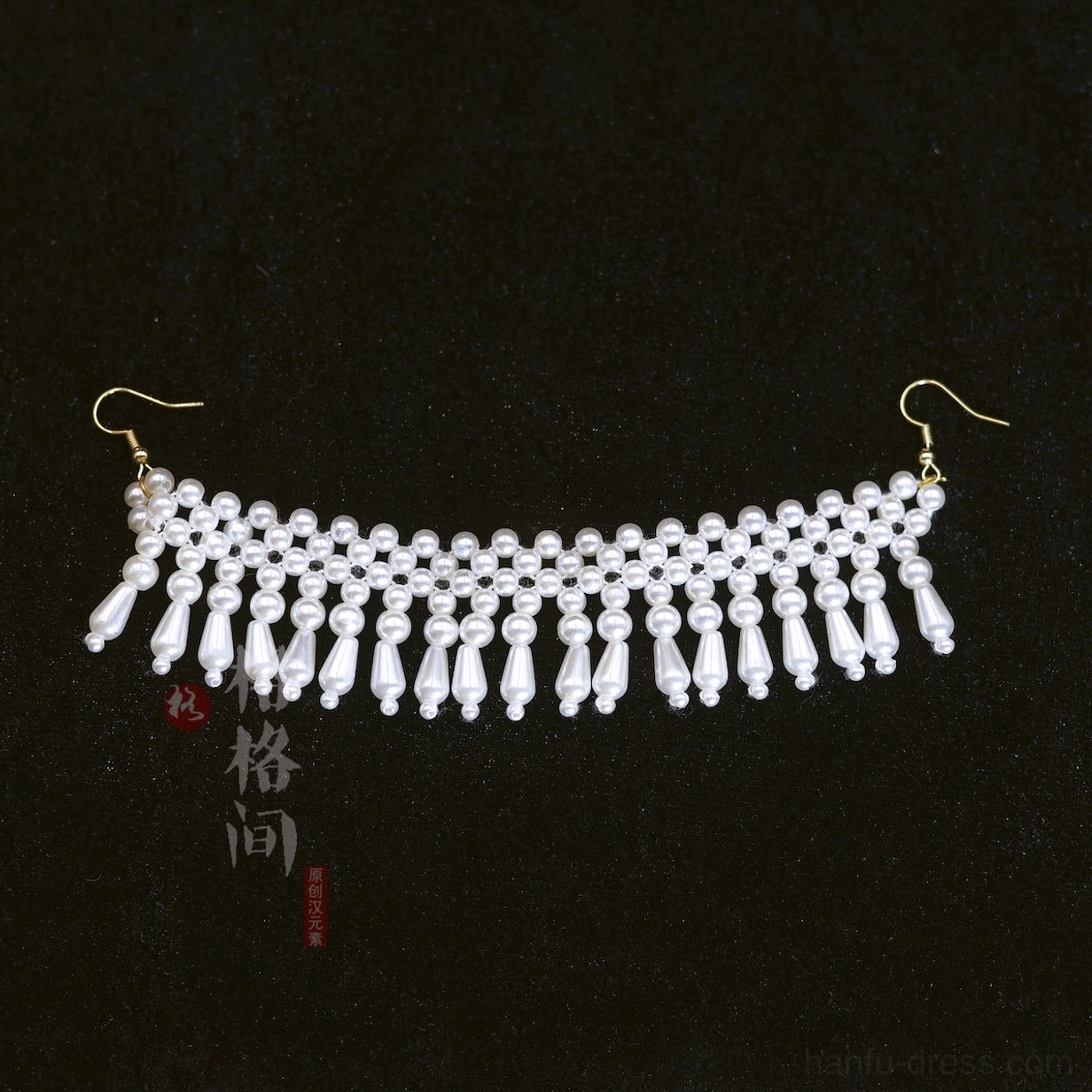 Pearl tassel Hanfu hair pin displayed on black fabric with curved white pearl row, gold tone hooks, and dangling pearl drops