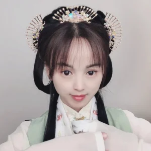 Model wearing a coordinated Chinese Hanfu hair ornament set with fan-shaped hairpins, iridescent flowers, and pearl decorations in an elegant traditional hairstyle