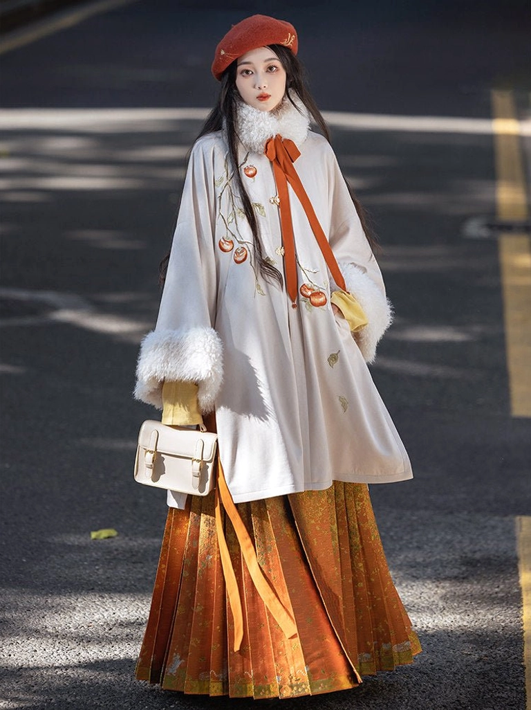 Full body outdoor view of persimmon Ming Dynasty Hanfu coat and burnt orange brocade Mamianqun skirt set