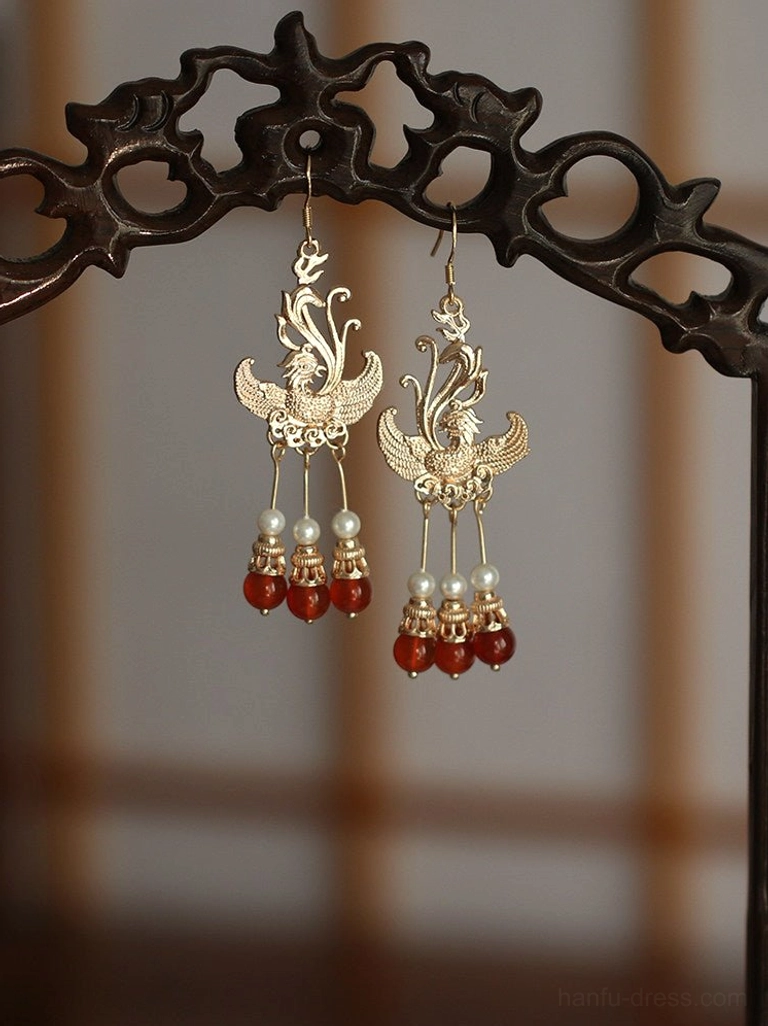 Phoenix bridal Hanfu dangle earrings with layered faux pearl and deep red bead tassels displayed against a traditional Chinese window grille