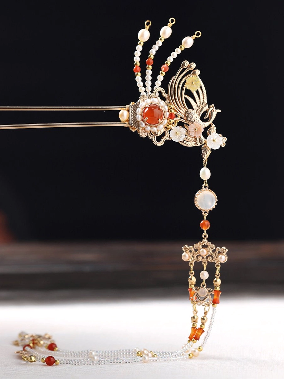 Gold phoenix tassel Chinese hair stick with red decorative stone pearl-like beads and layered chain tassels on dark wood