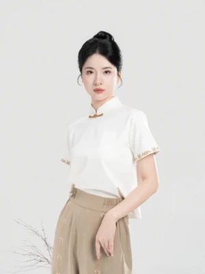 Close-up of ivory modern Hanfu short sleeve top with Mandarin collar Chinese frog closure and embroidered cuffs