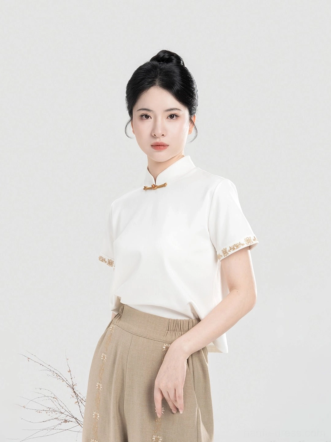 Close-up of ivory modern Hanfu short sleeve top with Mandarin collar Chinese frog closure and embroidered cuffs