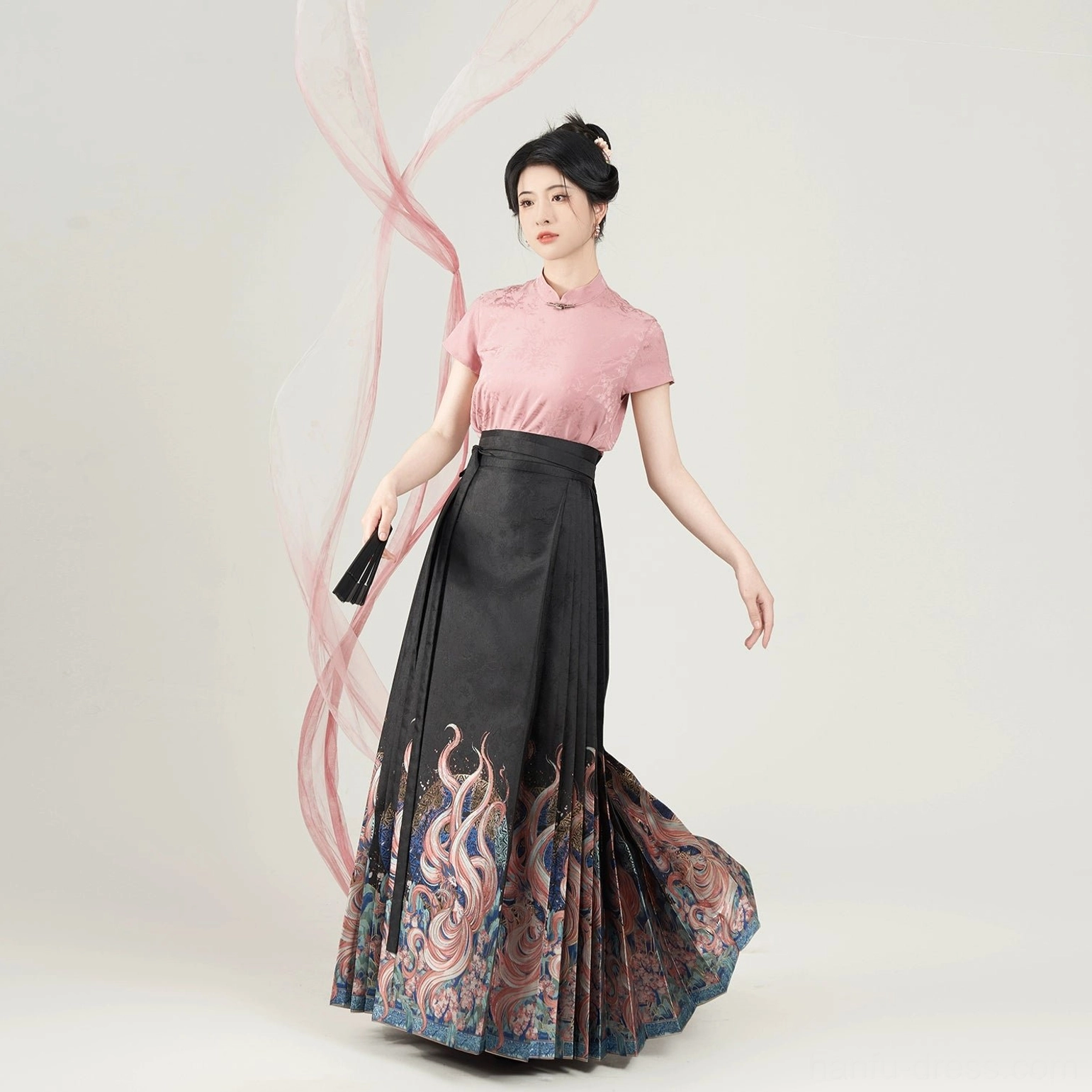 Pink blouse and flowing black Nine-Tailed Fox mamian skirt styled as a Ming-inspired Hanfu outfit with folding fan
