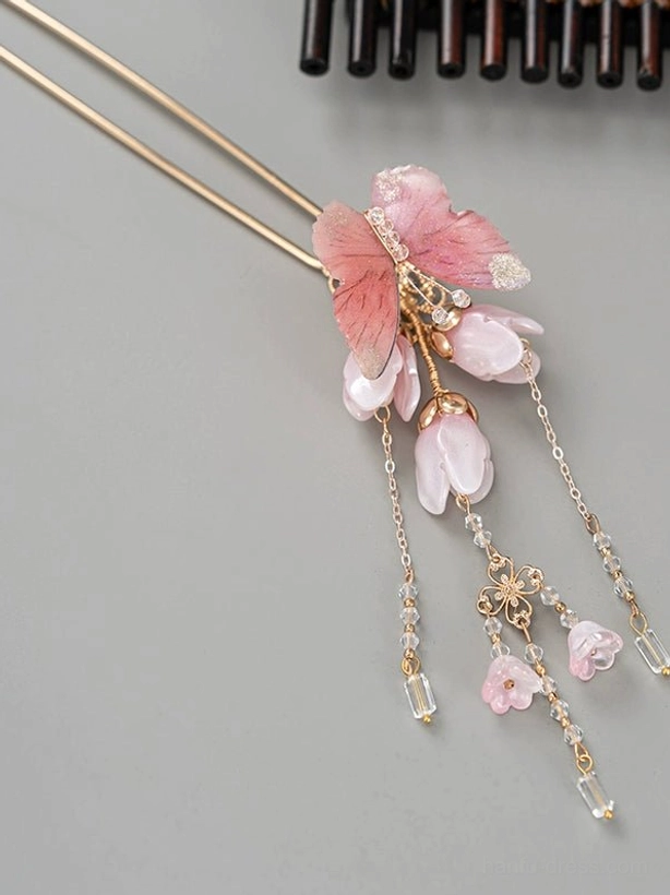 Side view of a delicate pink butterfly and magnolia Chinese hair stick with small flower charms and hanging tassels