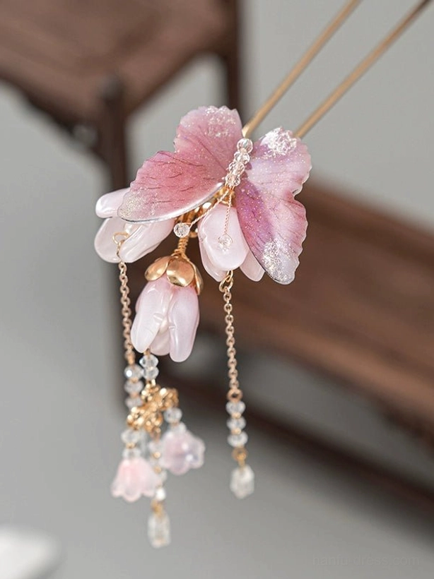 Close-up of a pink butterfly magnolia Chinese hair stick with rhinestone detail and layered dangling tassel pendants