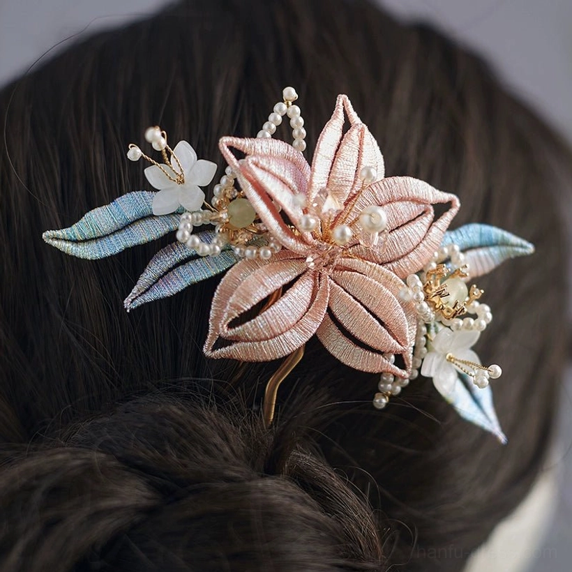 Close-up back view of pink Chinese floral hairpin with blue thread-wrapped leaves, pearl details and gold hair fork in a traditional Hanfu bun hairstyle