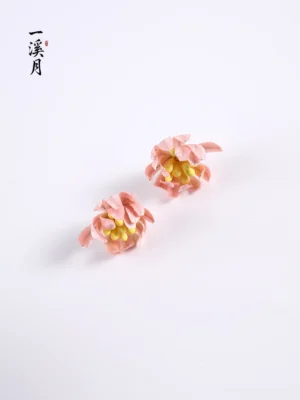 Pair of pink chrysanthemum velvet flower stud earrings with layered petals and yellow stamens displayed on a clean white studio background