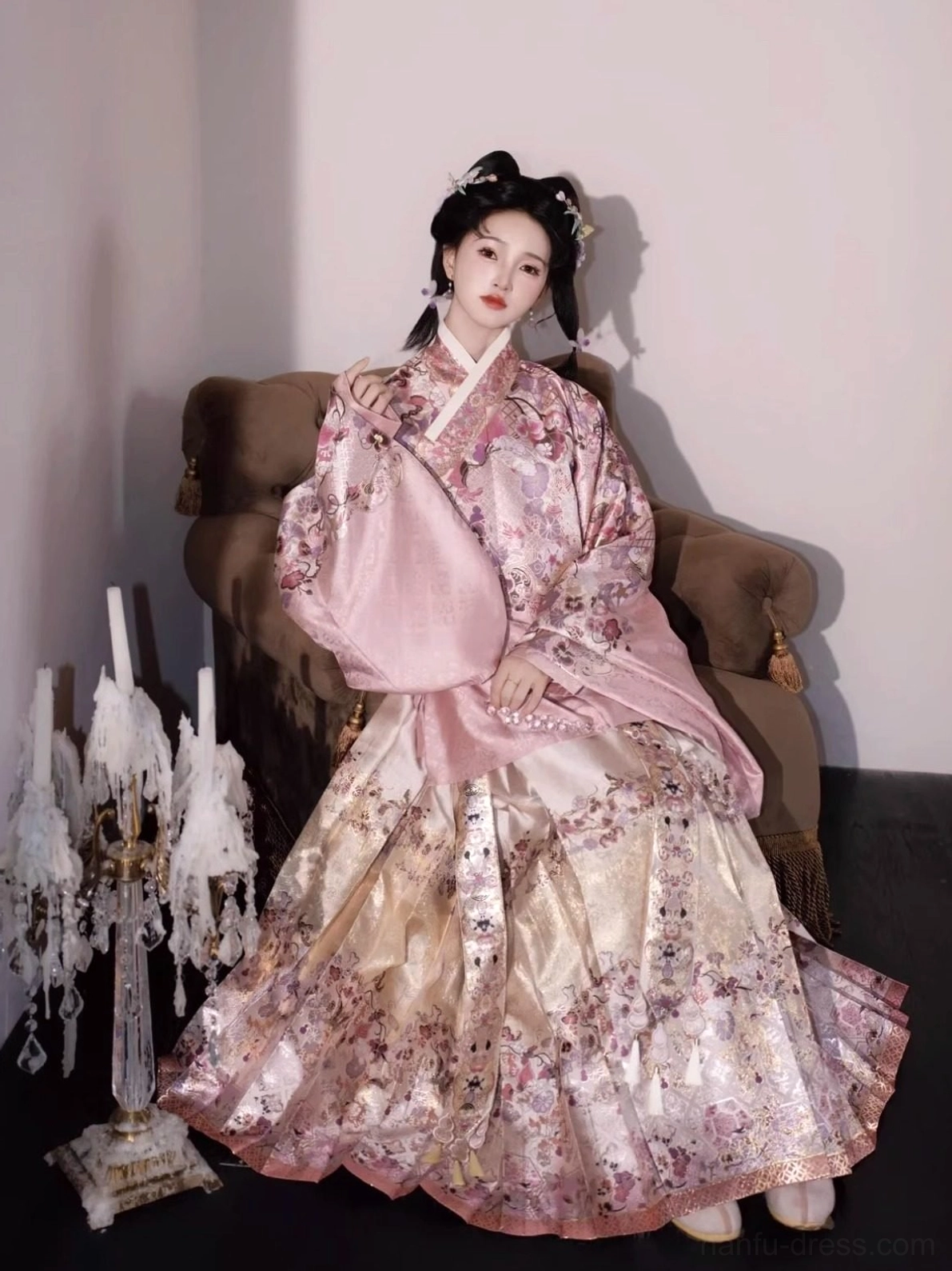 Elegant seated three-quarter view of a pink and cream Ming Dynasty floral hanfu two-piece set with traditional hair styling