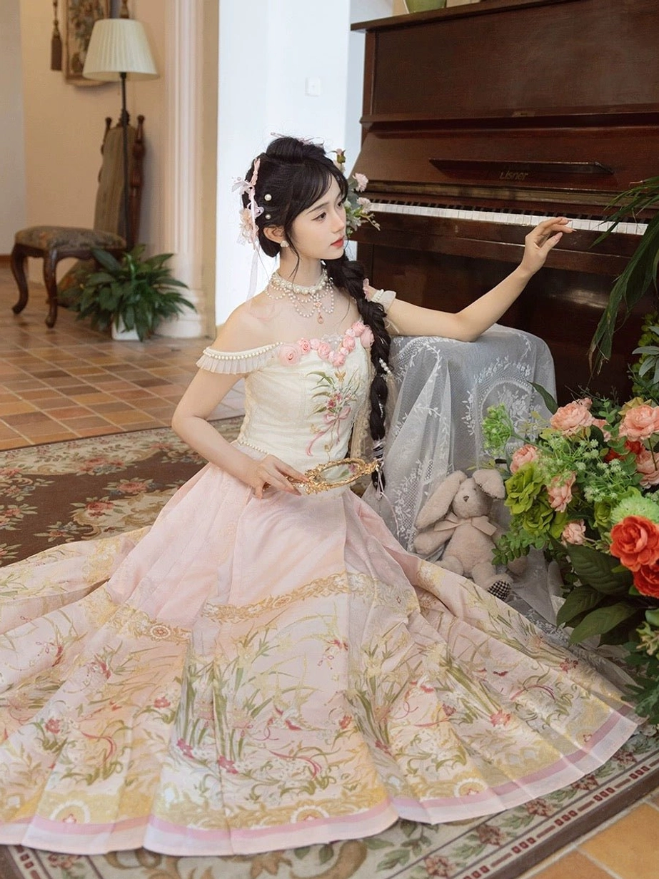Overhead view of a pink and cream Ming inspired modern Hanfu set displayed beside a grand piano, showing the full pleated skirt and floral embroidery