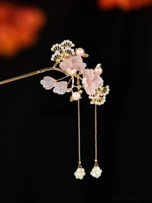 Traditional Chinese floral tassel hair stick with pink translucent flowers, gold-toned metal branches, pearl accents, and dangling pearl tassels on a dark background