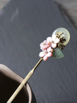 Pink floral full moon Chinese hair stick with jade-inspired round pendant, green leaves, antique bronze details, and brass hairpin shaft for Hanfu hairstyles