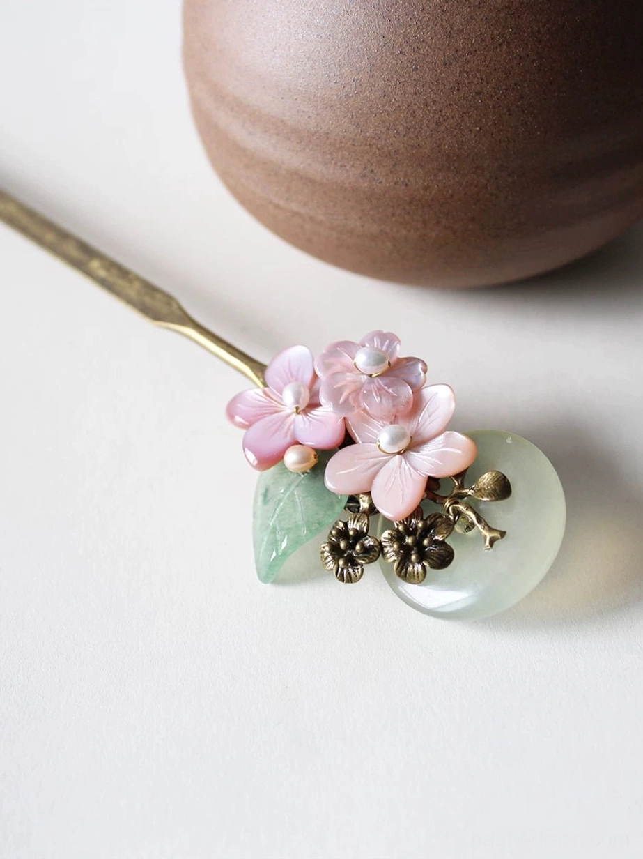 Pink flower Hanfu hair stick with pearl-centered blossoms, round jade-look full moon pendant, green leaf accents, and slim brass hair shaft