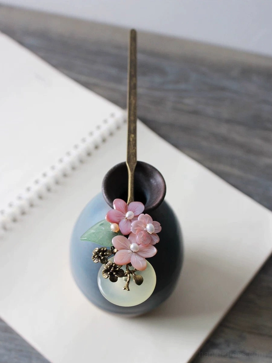 Vintage-inspired Chinese hair stick for Hanfu with pink blossoms, jade-inspired circular pendant, green leaf decoration, and antique bronze hair accessory details