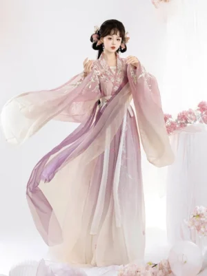 Pink gradient Qiyao Ruqun Hanfu three quarter back view showing flowing wide sleeves, fluttering wrap skirt, floral embroidery, and decorative waist belt