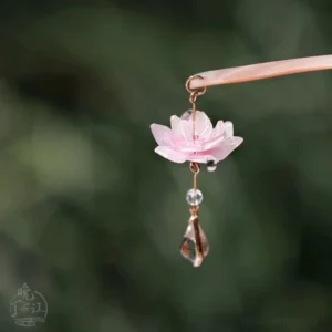 Close-up of layered pink lotus pendant on Chinese hair stick with gold-tone details, clear bead, and faceted teardrop drop