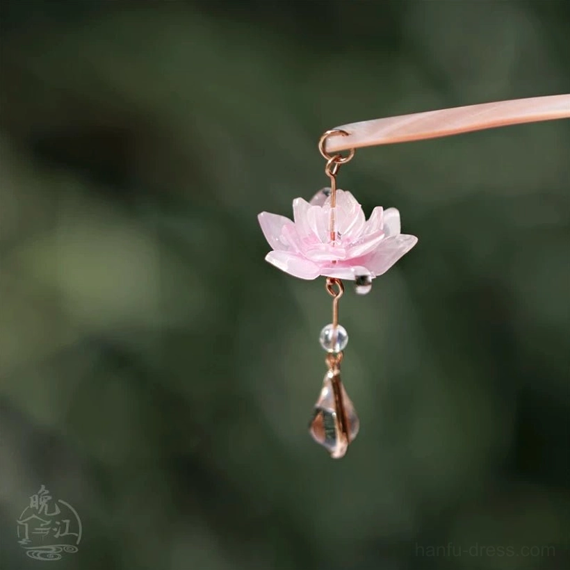 Close-up of layered pink lotus pendant on Chinese hair stick with gold-tone details, clear bead, and faceted teardrop drop