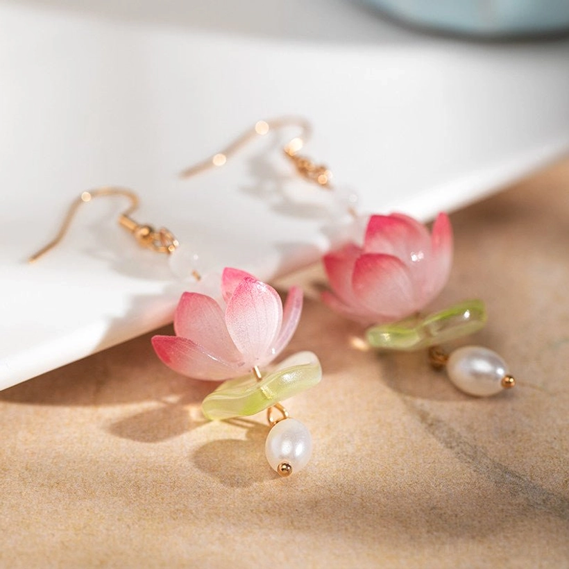 Pink lotus clip-on dangle earrings with gold clip fasteners, green decorative accents, delicate chains, and pearl pendants